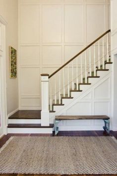 a stair case in an empty room with carpet on the floor and rug on the ground