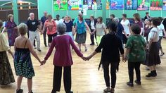 a group of people holding hands and dancing