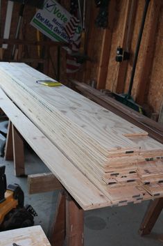 several pieces of wood sitting on top of each other in a room filled with construction tools