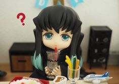 a figurine is sitting at a table with food and drinks in front of it