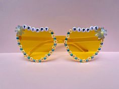 "Bedazzled yellow heart \"trippy hippie\" sunglasses perfect for brunch, a rave, or a day at the beach. All sunglasses are decorated with love and care by hand." Fun Sunglasses For Summer Music Festivals, Fun Summer Sunglasses For Music Festivals, Fun Spring Festival Sunglasses, Festival Fun Sunglasses With Mirrored Lenses, Fun Festival Sunglasses With Tinted Lenses, Fun Handmade Sunglasses For Summer, Bohemian Sunglasses For Summer Parties, Fun Summer Festival Sunglasses, Handmade Fun Summer Sunglasses