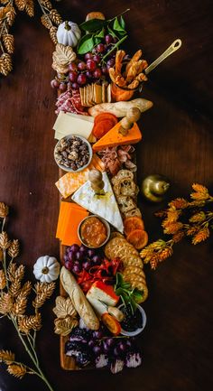 a wooden table topped with lots of cheese and crackers