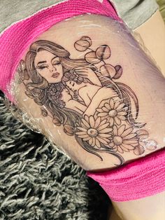 a woman's arm with a tattoo on it and flowers in the middle of her leg