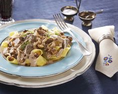 a blue plate topped with pasta and mushrooms