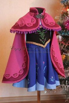 a pink and blue dress on display in front of a christmas tree