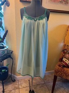 What a sweet little nighty for the summer evenings, mint green double layer nylon with shoulder straps and dark green floral design around the neck line, above the knee with green at the hem line Size Medium Measurements: Chest 17 1/2 laid flat across Length from armpit to hemline 25" Green Fitted Camisole For Vacation, Summer Coquette Style Nightgown For Bedtime, Summer Coquette Nightgown For Bedtime, Coquette Summer Nightgown For Bedtime, Coquette Nightgown For Bedtime In Summer, Green Nightgown For Sleepover, Sheer Coquette Sleepwear For Summer, Green Sleeveless Sleep Camisole, Green Camisole For Beach In Spring