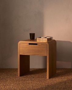 a small wooden table with a cup on it