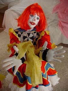 a creepy clown doll sitting on the floor