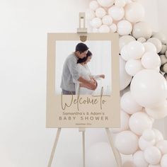 a welcome sign with balloons in the background and a baby's photo on it