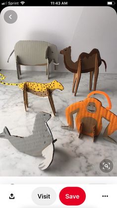 an image of some animals made out of paper on the floor in front of a wall