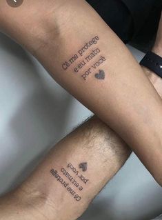 two people with matching tattoos on their legs, one is holding the other's leg