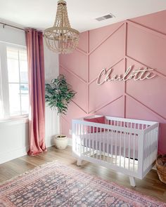 a baby's room with pink walls and white crib