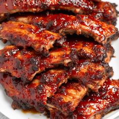 barbecue ribs covered in bbq sauce on a white plate