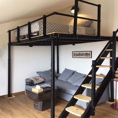 a loft bed with stairs leading up to the top floor and couch below it in a living room