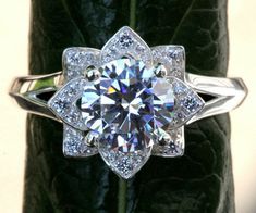 a diamond ring sitting on top of a green plant