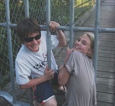 two young boys are playing on the stairs together and one boy is holding onto the bars