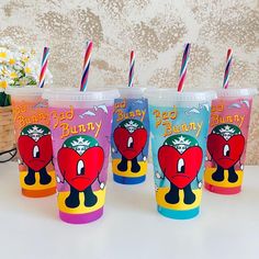 three plastic cups with straws in them sitting next to each other on a table