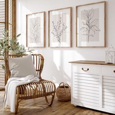 a room with white walls and wooden flooring is furnished with wicker furniture, framed pictures on the wall