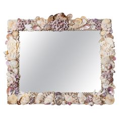 a mirror with seashells and shells on the bottom, in front of a white background