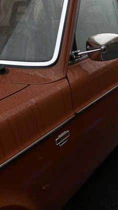 an old brown car parked on the street