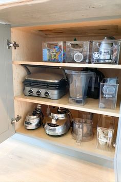 a kitchen cupboard with various appliances and containers