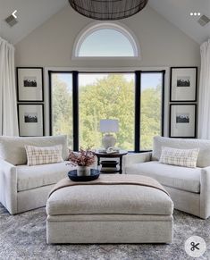 a living room with two couches and a coffee table in front of a large window