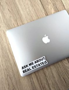 an apple laptop sitting on top of a wooden table