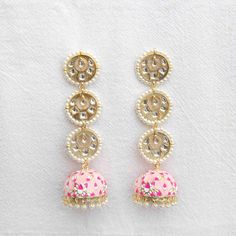 Accessorize your outfit with our cute baby pink Rasika jhumka earrings, a meenakari-style, hand-painted jhumka with embedded gemstones and pearls. Did you know that the word "rasika" means passionate in the Sanskrit language? Specifications Materials used: hand-painted jhumka, gemstones, pearls At Romikas, we pride ourselves on the craftsmanship and high quality of our jewelry, designed to enhance your natural beauty. Please contact us with any questions. White Meenakari Fusion Jhumkas, Fusion Meenakari Earrings For Diwali, Festive Navratri Jewelry With Matching Earrings, Fusion Style Meenakari Earrings For Diwali, Navratri Celebration Jewelry With Matching Earrings, Festive Matching Earrings For Navratri, Beaded Drop Earrings For Festivals, Celebration Jewelry With Matching Earrings For Navratri, Festive Fusion Meenakari Earrings