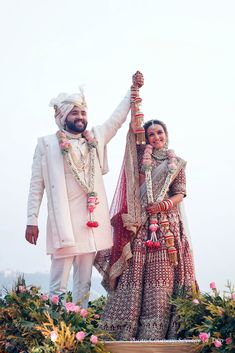 a bride and groom standing on top of a hill