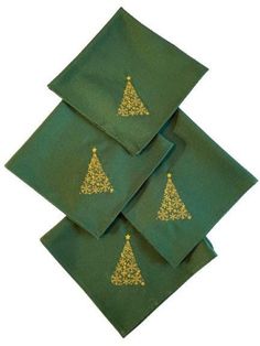 four green napkins with gold christmas trees on them