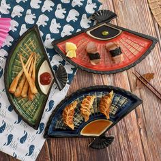 three plates filled with food on top of a wooden table next to chopsticks