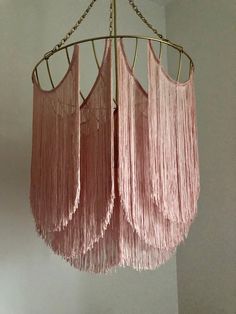 three pink chandeliers hanging from a ceiling