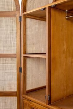 an open wooden cabinet with wicker doors