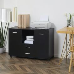 a desk with a printer on it next to a wooden table and some other items