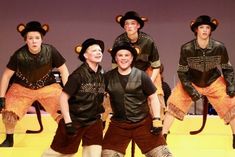 a group of young men standing next to each other on top of a yellow floor