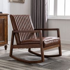 a brown rocking chair sitting on top of a rug