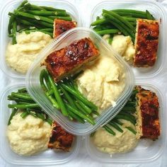 four plastic containers filled with food on top of a white table covered in green beans and mashed potatoes