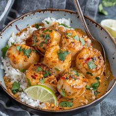 a bowl filled with shrimp and rice on top of a table next to a lemon wedge