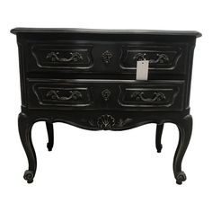 an ornate black dresser with drawers