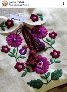 an embroidered shirt with flowers and tassels on it