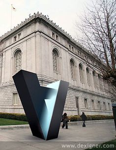 an artistic sculpture in front of a large building with people walking around the courtyard and trees