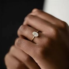 a woman's hand with a diamond ring on it