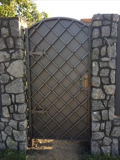 an iron gate is shown with stone walls