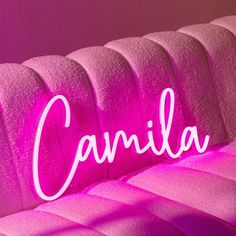 a pink couch with the word candia lit up on it's back side