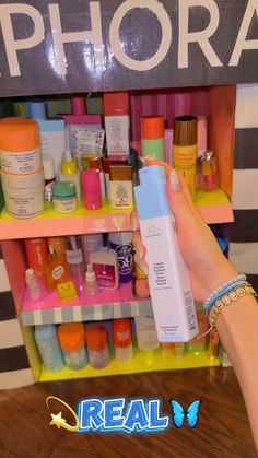 a person holding up a bottle in front of a shelf filled with cosmetics and personal care products