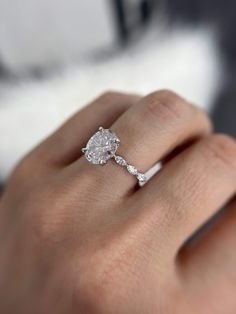 a woman's hand with a diamond ring on it