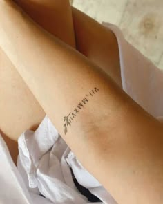 a woman's arm with the word mama written on it and an arrow tattoo