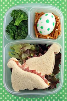 a plastic container with food in it on a green tablecloth and polka dot background