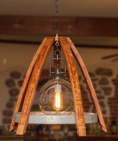 a light fixture made out of wooden planks and an old fashioned bulb hanging from the ceiling