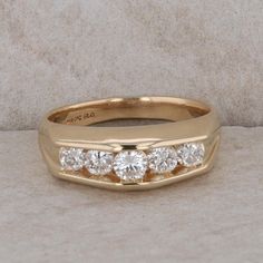 This men's 14k yellow gold ring has five round brilliant cut diamonds that measure approx 1.00cttw. They are G-H in color and SI1 in clarity. It weighs 9.0 grams and the finger size is 9.5. The ring measures 7.7 mm in height and 17.5 mm in length, with the biggest diamond coming to a point at the top of the ring. Condition: Pre-Owned *All items are thoroughly inspected for quality assurance purposes Big Diamond, Channel Set, Ring Pictures, Round Brilliant Cut Diamond, Yellow Gold Rings, Rings Statement, Ring Shopping, Statement Rings, Jewelry Watches